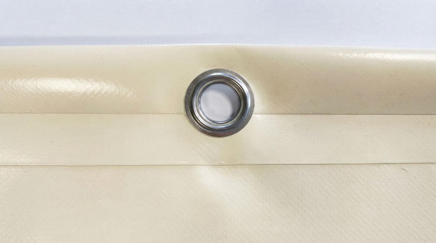 Gros plan sur la finition professionnelle d'une bâche PVC montrant œillets métalliques espacés de 50 cm et ourlet thermosoudé renforcé pour durabilité extérieure